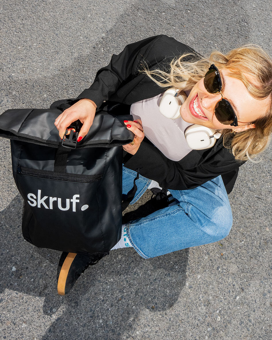 Person mit skruf Rucksack sitzt auf Boden