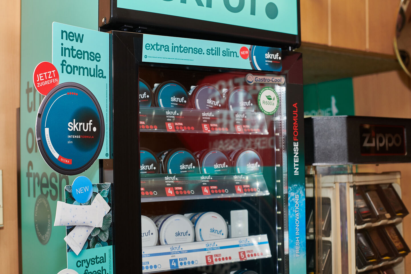 Kühlschrank mit skruf.-Dosen und Werbeschildern zur neuen intensiven Formel.
