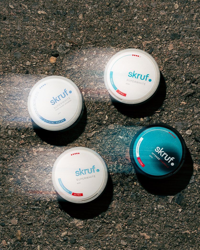 Nahaufnahme von vier skruf Nikotinbeutel Dosen, die auf der Straße liegen