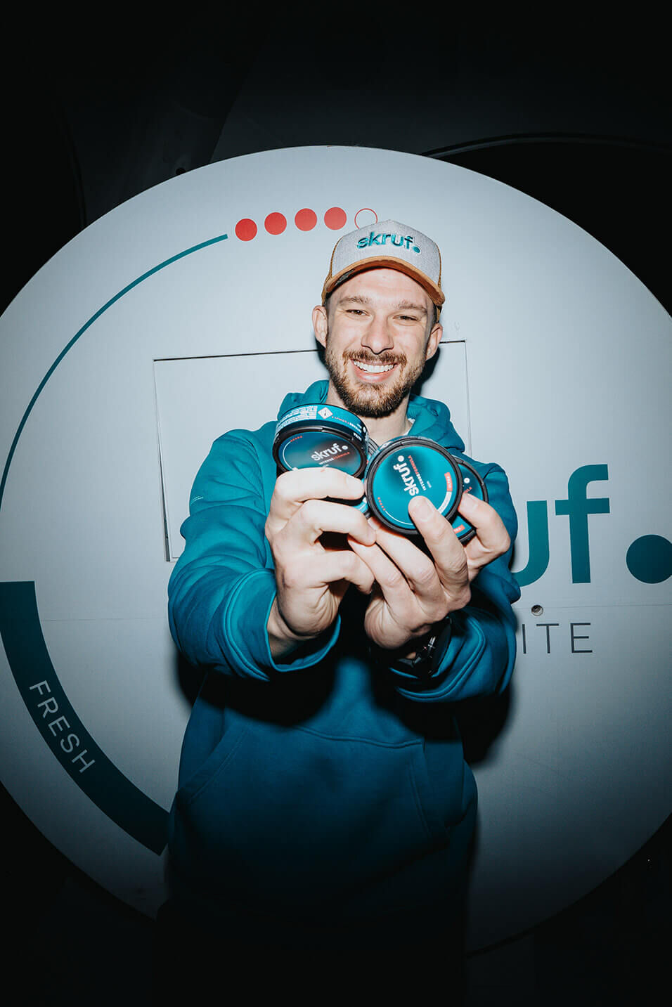 Mann präsentiert skruf Nikotinbeutel-Dosen vor der Kamera.