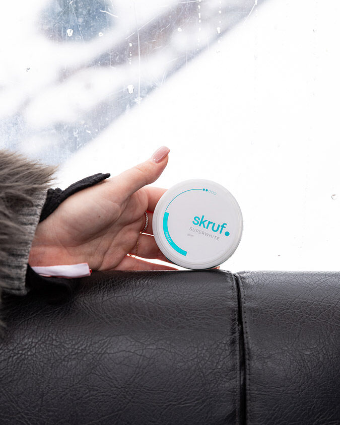 skruf Nikotinbeutel Dose auf der Oberseite der Rückenlehne einer Gondelbank