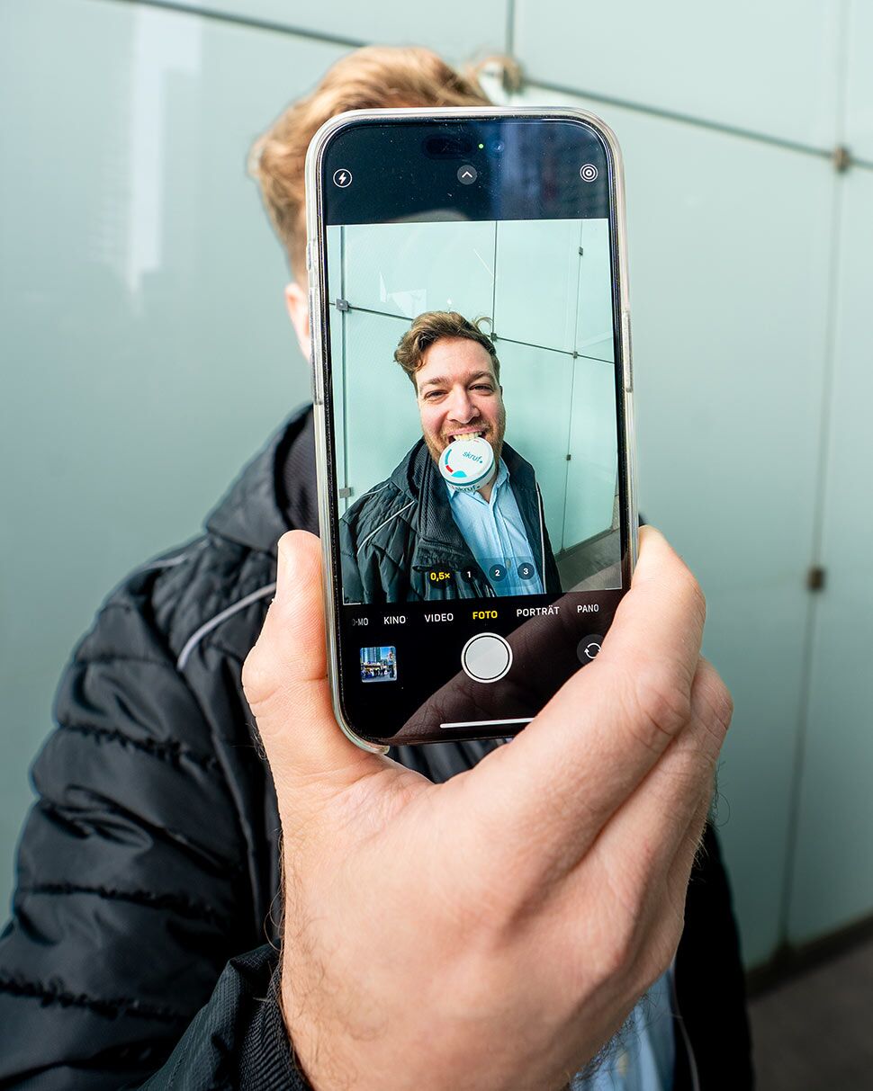 Smartphone zeigt Person mit skruf Dose