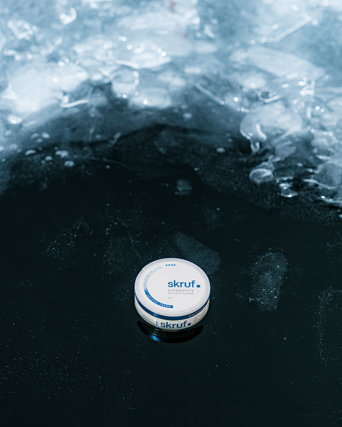 Skruf Superwhite Dose auf Eis mit reflektierender Oberfläche.