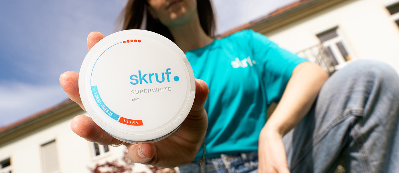 Frau hält eine Dose skruf Slim Pouches in die Kamera.